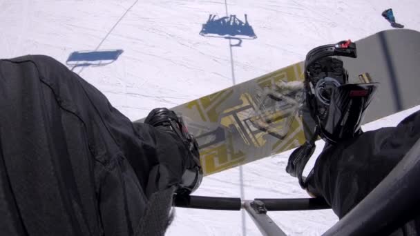 Blick Auf Die Beine Eines Snowboarders Der Auf Einem Sessellift — Stockvideo