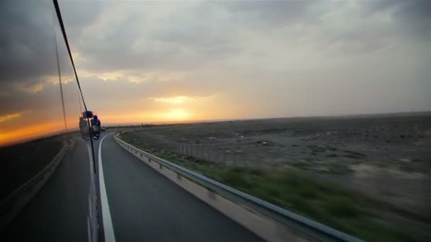 Bussen går på motorvägen vid solnedgången, Kina. — Stockvideo