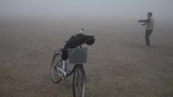 Ember játszik Diabolo a parkban habos a köd reggel, Xian, Shaanxi, Kína — Stock videók