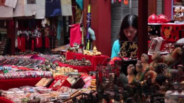 XIAN, Çin - 26 Mayıs 2012: Kimliği belirsiz insanlar Çin 'in Xian kentindeki alışveriş caddesindeki tezgahtan geleneksel hediyeleri seçiyorlar.