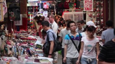 XIAN, Çin - 26 Mayıs 2012: Kimliği belirsiz insanlar Çin 'in Xian kentindeki alışveriş caddesindeki tezgahtan geleneksel hediyeleri seçiyorlar.