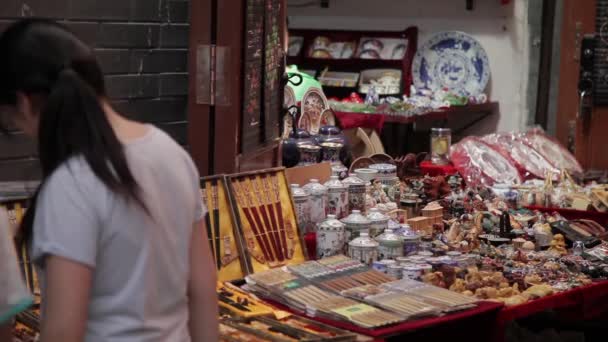 XIAN, CHINA - MAIO 26, 2012: Pessoas não identificadas escolhem lembranças tradicionais na barraca da rua comercial em Xian, China. — Vídeo de Stock