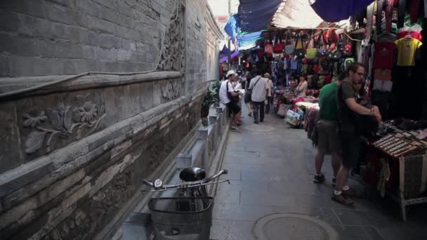 XIAN, CINA - 26 MAGGIO 2012: Persone non identificate scelgono souvenir tradizionali presso la bancarella della via dello shopping a Xian, Cina. — Video Stock