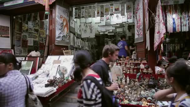 XIAN, KINA - MAJ 26, 2012: Oidentifierade människor väljer traditionella souvenirer i båset vid shoppinggatan i Xian, Kina. — Stockvideo