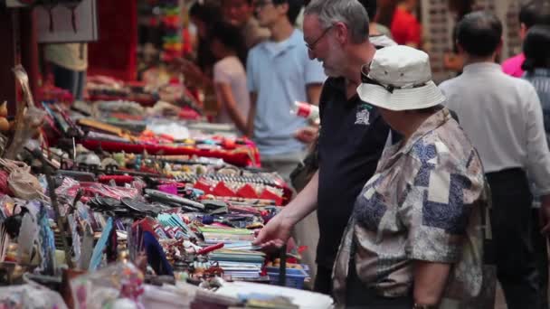 XIAN, CHINA - MAJ 26, 2012: Niezidentyfikowani ludzie wybierają tradycyjne pamiątki na stoisku przy ulicy handlowej w Xian, Chiny. — Wideo stockowe