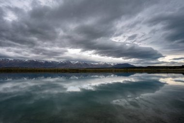 göl ve dağlarda dramatik gökyüzünün yansıması
