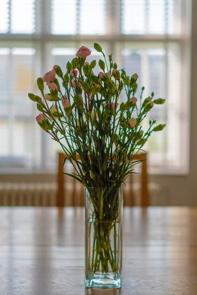 bouquet of carnation in a vase on wooden table
