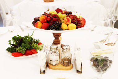 Meyve ve otlarla dolu beyaz masa..