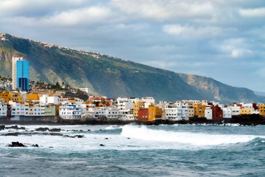 Okyanus kıyısında ve Punta Brava, Puerto de la Cruz, Tenerife, Kanarya Adaları 'ndaki kayadaki renkli binalara bakın.