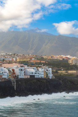 Okyanus kıyısında ve Punta Brava, Puerto de la Cruz, Tenerife, Kanarya Adaları 'ndaki kayadaki renkli binalara bakın.