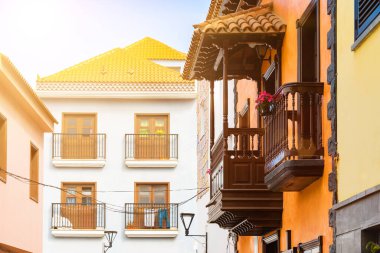 İspanya 'nın Punto Brava, Tenerife, Kanarya Adaları, İspanya' nın dar bir kasabasındaki renkli binaların üzerinde parlak güneş.