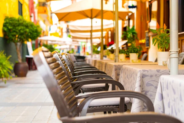 Stoelen en tafels in een café in een smalle straat in Puerto de la Cruz, Tenerife, Spanje. Niemand.. — Stockfoto