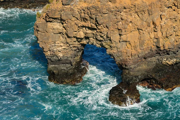 Wellen brechen auf den Felsen im Meer, Grottenfelsen. Ozeanische Felsformationen an der Küste. Teneriffa, Spanien — Stockfoto