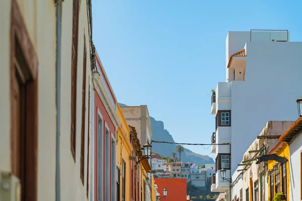 Edifícios coloridos em uma rua estreita na cidade espanhola Garachico em um dia ensolarado com vista para as montanhas, Tenerife, ilhas Canárias, Espanha . — Fotografia de Stock