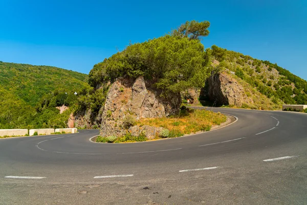 Сценическая извилистая дорога изгибается в горном массиве Анага против ярко-голубого неба Тенерифе, Испания . — стоковое фото