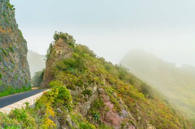 Dağlarda bir yol, bir uçuruma oyulmuş. Bulutlardaki dağlar. Tenerife, İspanya