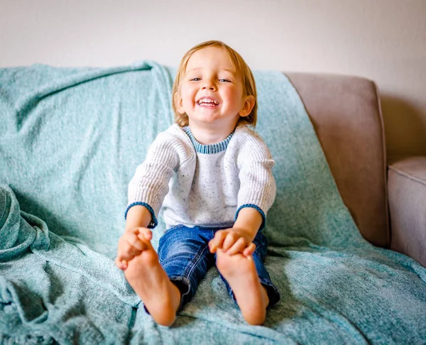 Happy Young Caucasian Boy Sits Grey Couch Ocean Blue Throw — Stock Photo, Image