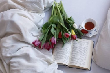 lale buketi, bir kitap ve çay