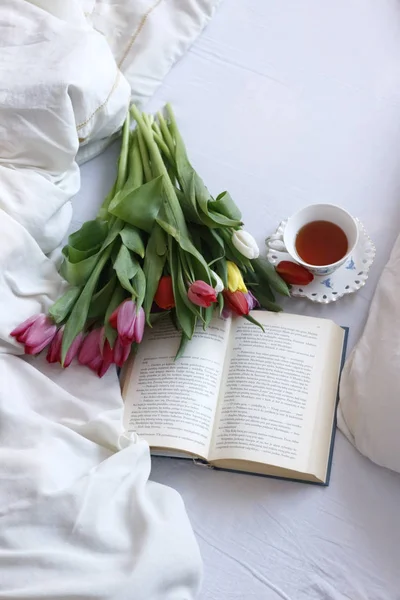 lale buketi, bir kitap ve çay