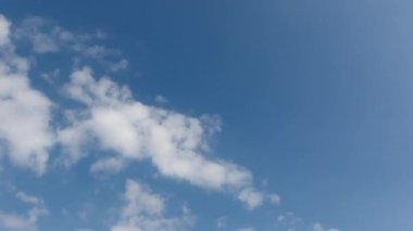 Zaman atlamalı. Mavi gökyüzünde hızla hareket eden bulutlar.