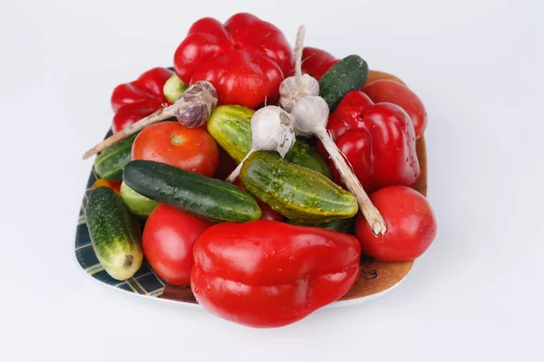 Pirospaprika, uborka, paradicsom és fokhagyma egy tányéron, fehér ba — Stock Fotó