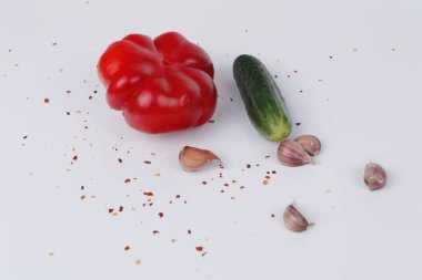 Kırmızı biber, salatalık, sarımsak ve baharatlar beyaz bir arka plan üzerinde