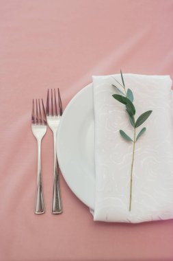 Masa düzenleme ve dekorasyon. Çatal, tabak, havlu ve çiçek.