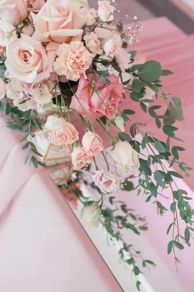 Kytice s růžemi a růžovým pupenem ve skleněné váze na růžovém hřbetě — Stock fotografie