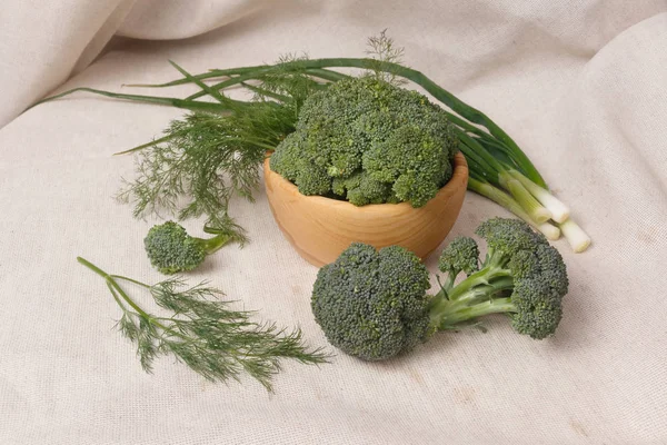 Bawang hijau, brokoli, dill dalam mangkuk kayu pada kain backgr — Stok Foto
