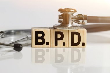 Tahta küplerin üzerindeki sözcüğü söyle, yansıtıcı beyaz bir yüzey, küplerin üzerinde duran bir stetoskop. Tıp konsepti