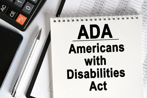 桌上放着一个智能手机 一个计算器和一个笔记本 上面写着 Ada 美国残疾人法 业务概念 — 图库照片