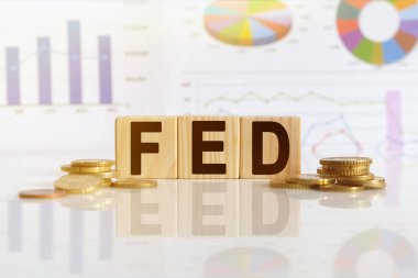 Federal Rezerv. Tahta küplerle beslenen sözcük, yansıtıcı yüzeyde duran küpler, arka planda bir iş diyagramı. İş ve finans kavramı