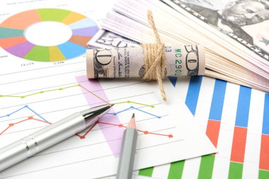 İş hedefi kavramı. İş aksesuarı, grafik çizelgeleri, kalem ve dolar masanın üzerinde..