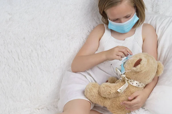 Chora Nastolatka Zakłada Medyczną Maskę Ochronną Dla Zabawki Koncepcja Medyczna — Zdjęcie stockowe