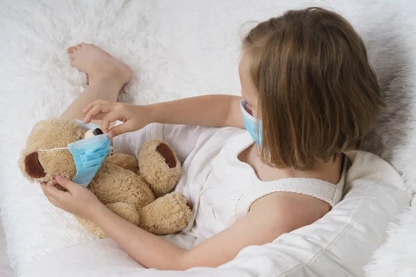 Chora Nastolatka Zakłada Medyczną Maskę Ochronną Dla Zabawki Koncepcja Medyczna — Zdjęcie stockowe