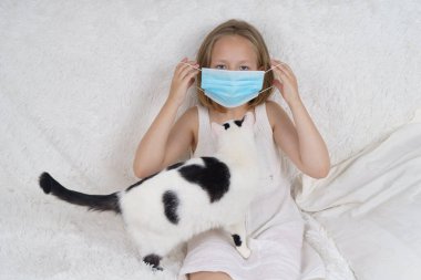 Yanındaki koruyucu maskeli hasta genç kız bir kedi. Tıbbi konsept.