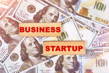 İş konsepti. Dolar banknotlarının arka planında, metin tahtadan bloklar üzerine yazılmıştır - iş açılışı