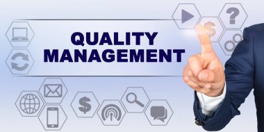 İş konsepti. İşadamı parmağıyla sanal ekrana dokunuyor. Ekran başlığı - Nitelik Yönetimi