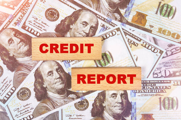 Бизнес-концепция. На фоне долларовых купюр текст написан на деревянных блоках - кредитный отчет