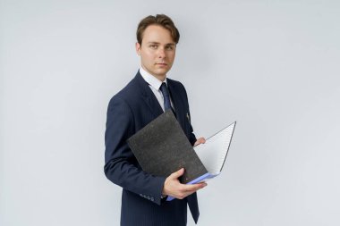 Mavi takım elbiseli bir iş adamı beyaz arka planda klasörler tutuyor. İş ve finans kavramı