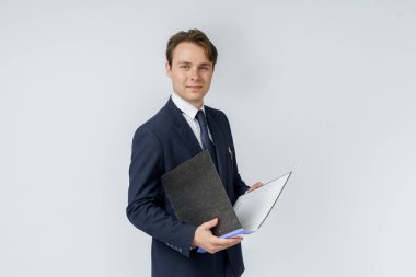 Mavi takım elbiseli bir iş adamı beyaz arka planda klasörler tutuyor. İş ve finans kavramı