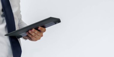 Beyaz arka planda elektronik tablet tutan mavi takım elbiseli bir iş adamının portresi. İş ve finans kavramı
