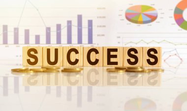 Ahşap küplerle ilgili kelime, yansıtıcı yüzeyde duran küpler, arka planda bir iş diyagramı var. İş ve finans kavramı