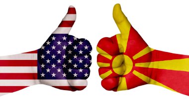 Ulusların ilişkilerini güçlendirme kavramı. İki el farklı ülkelerin bayraklarıyla boyanır ve başparmak kaldırılır. Makedonya ve ABD