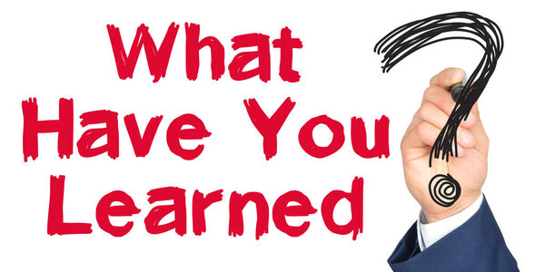 Hand with marker writing: What Have You Learned. Hand of a businessman with a marker.