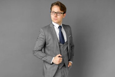 Yan tarafa bakan takım elbiseli bir iş adamının portresi. Gri arka plan iş ve finans kavramı