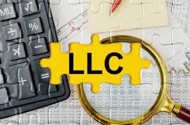 İş konsepti. Merkez yazıtında bir hesap makinesi, büyüteç ve mali belgeler ile bulmaca - LLC