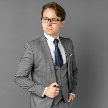 Yan tarafa bakan takım elbiseli bir iş adamının portresi. Gri arka plan iş ve finans kavramı