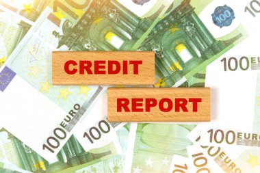 İş konsepti. Avro banknotlarının arka planında, metin tahtadan bloklara - kredi raporu