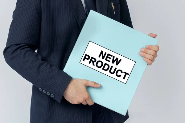 Business concept. A businessman holds a folder with documents, the text on the folder is - NEW PRODUCT